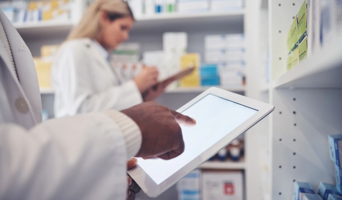 Profesionales de farmacia revisando información clínica en una tableta